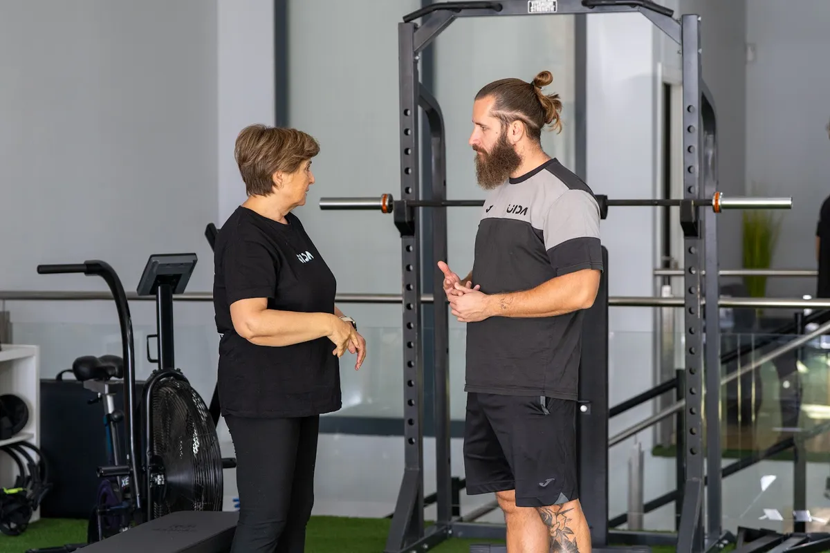 Entrenador y socia en la zona de racks